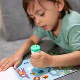 Kind drukt de dinosaurus-stickerstempel op een activiteitenpagina met dinosaurussen en ronde stickers.